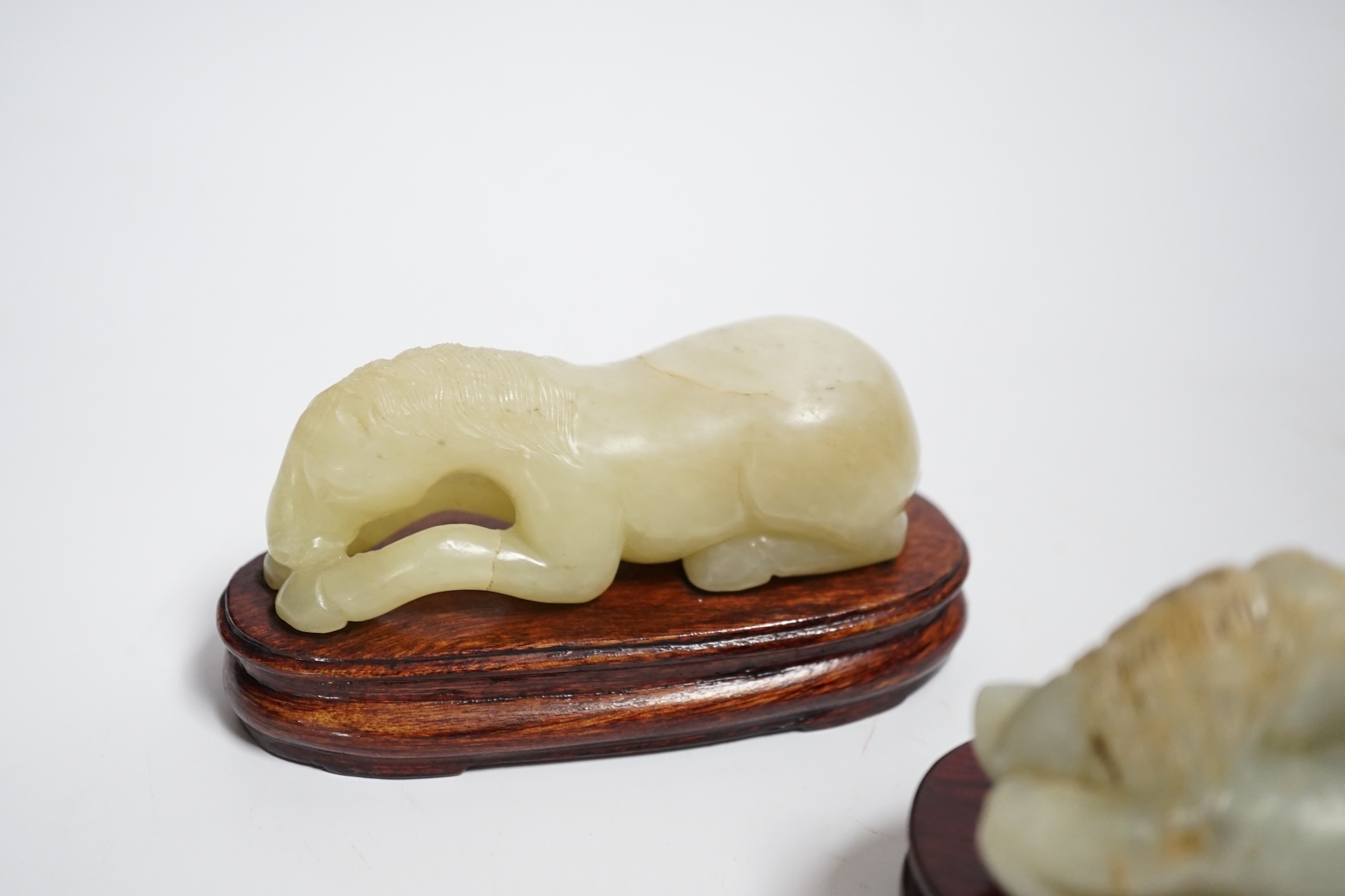Two Chinese carved jade figures of horses on stands, largest 11cm wide